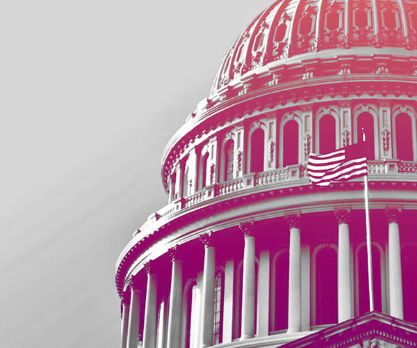 A close-up of the U.S. Capitol Dome that's been colored grey, pink, and purple.