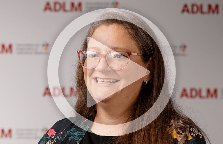 Still from a video featuring Amy Pyle-Eilola with a play button superimposed to indicate the link goes to a video