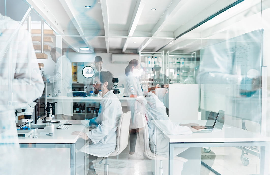Busy laboratory technicians working in background