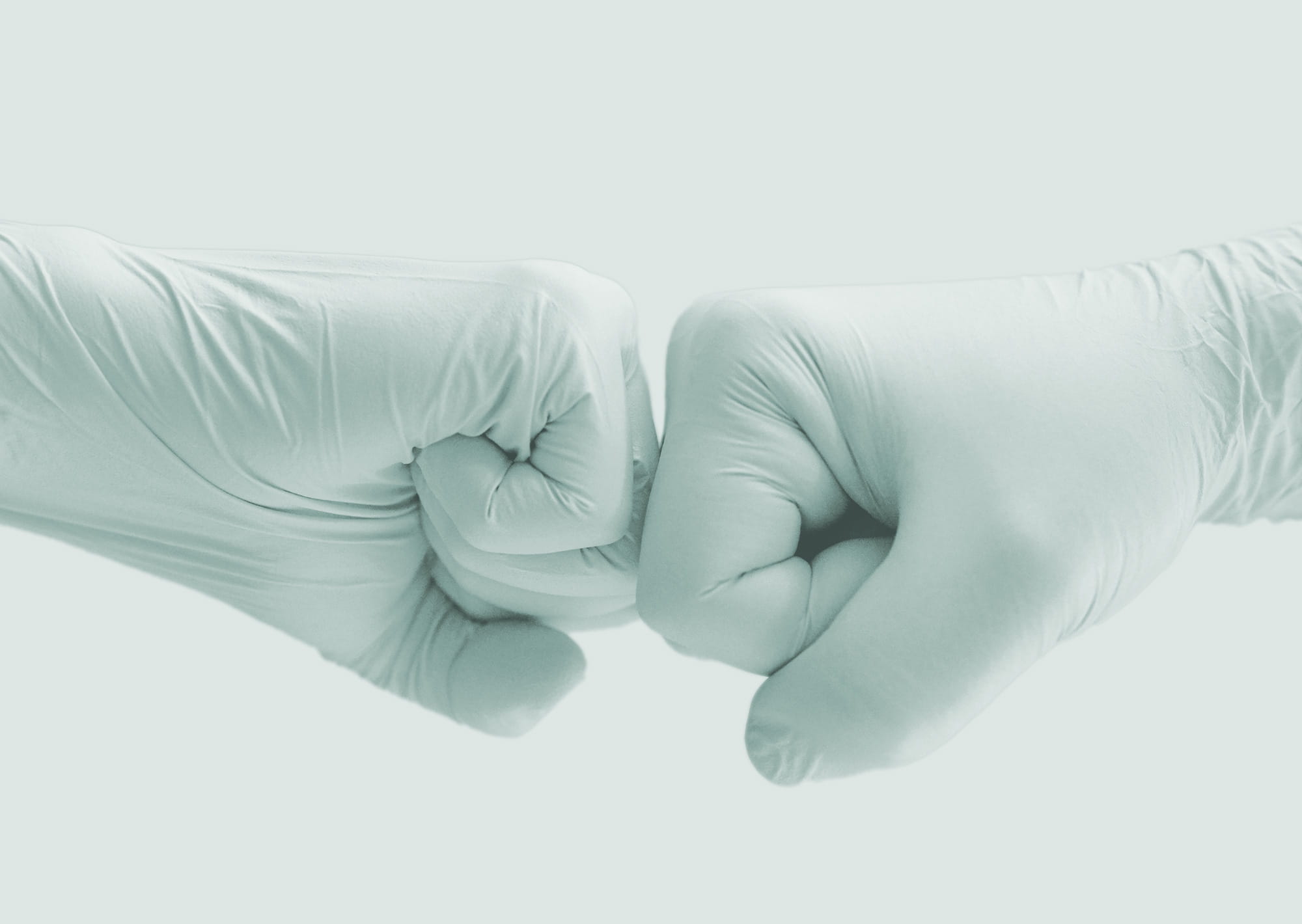 Two fists in surgical gloves bumping