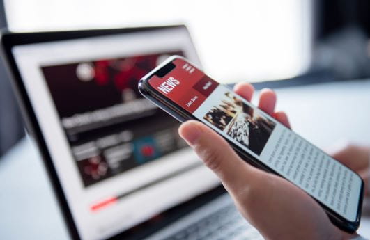 A close-up of someone's phone as they read the news on it.