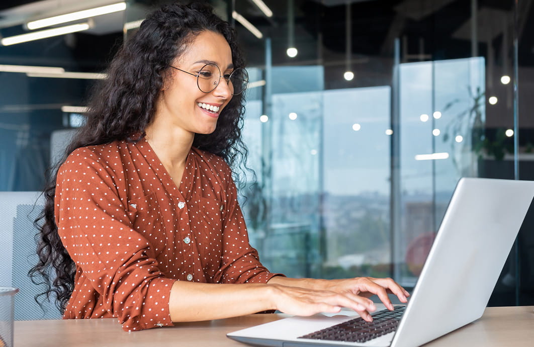 Woman working at laptop in modern office space