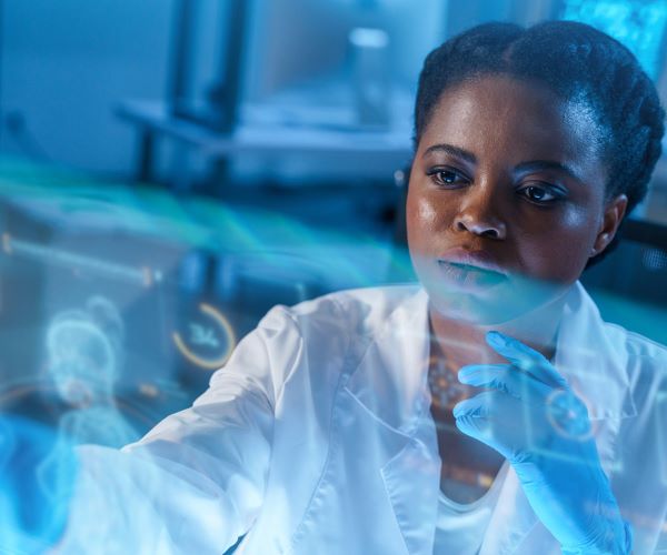 A laboratory medicine professional concentrates on a screen showing data analytics graphics.