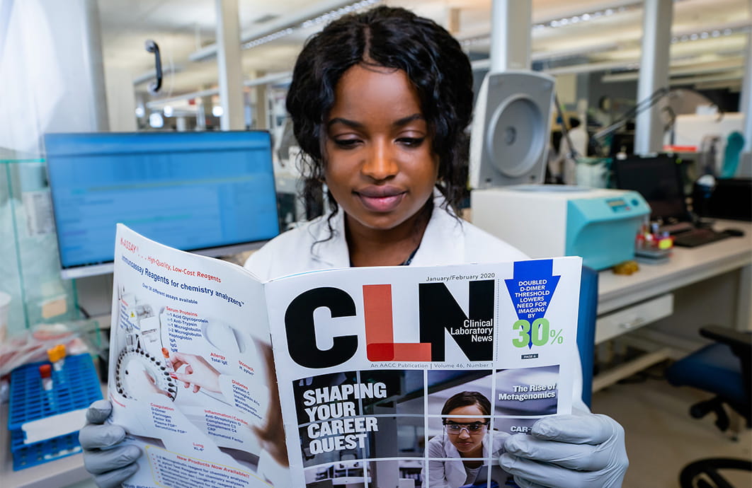A laboratorian reads an issue of Clinical Laboratory News.