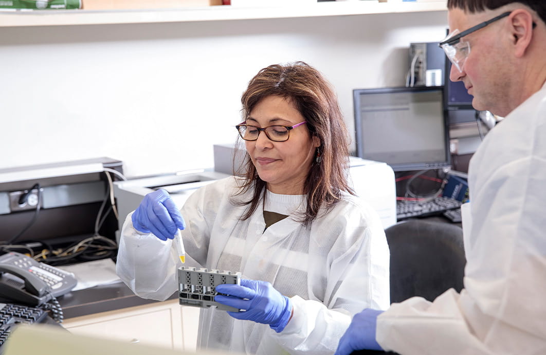 Two laboratorians handle patient samples.