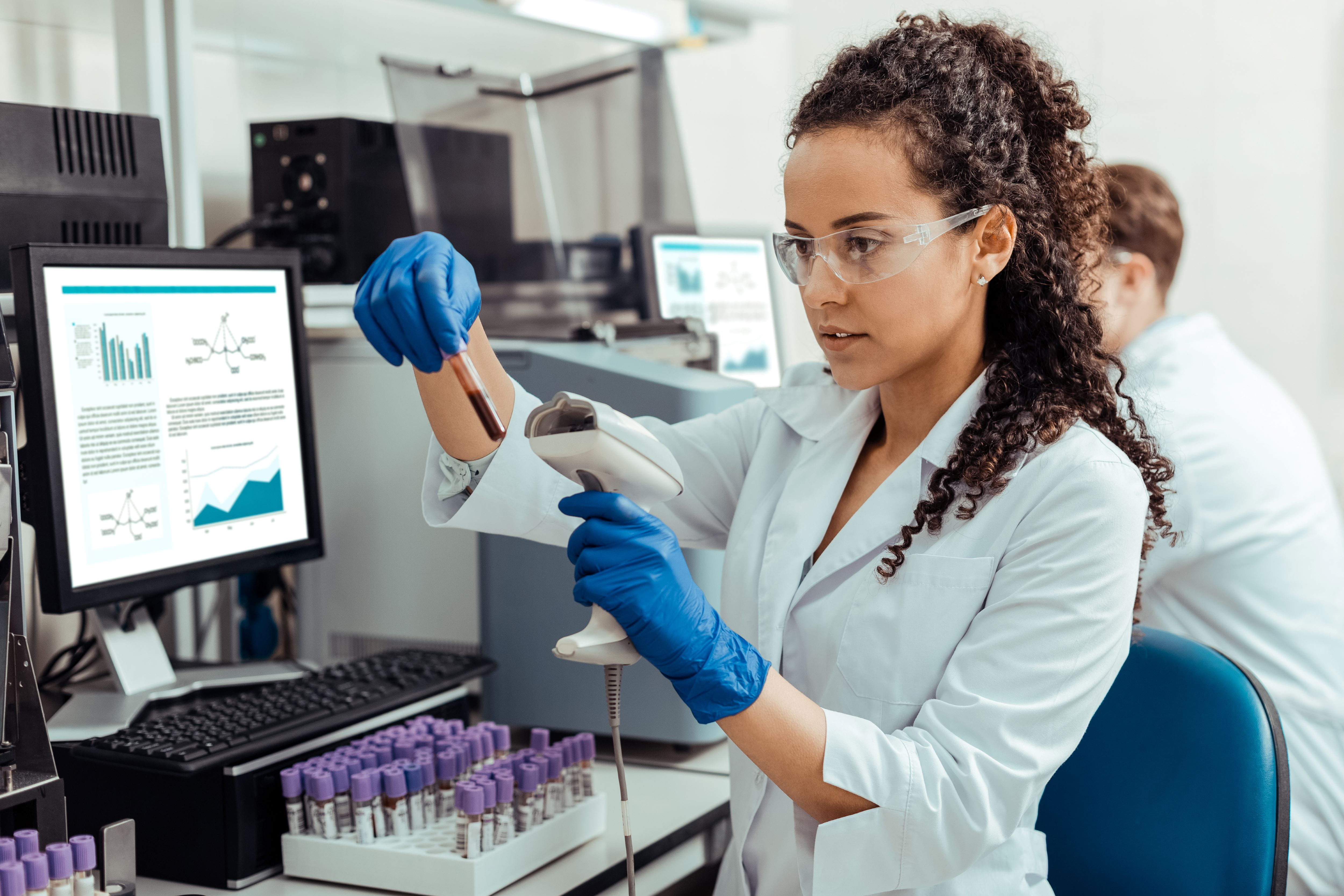 Woman laboratorian scanning a test tube of blood